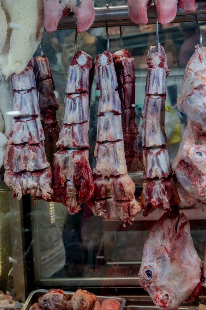 Close-up of hanging raw beef cuts in a traditional İzmir market.